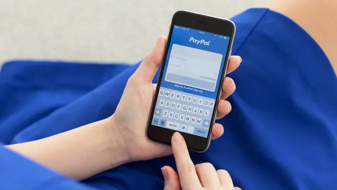 Alushta, Russia - December 3, 2014: Woman holding iPhone 6 Space Gray with service PayPal on the screen.