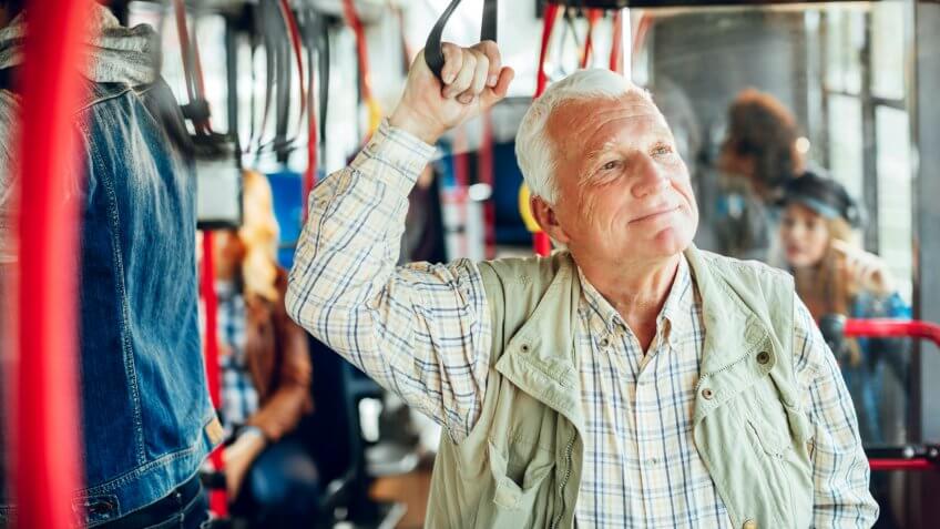 Close up of a mature man riding in a bus.