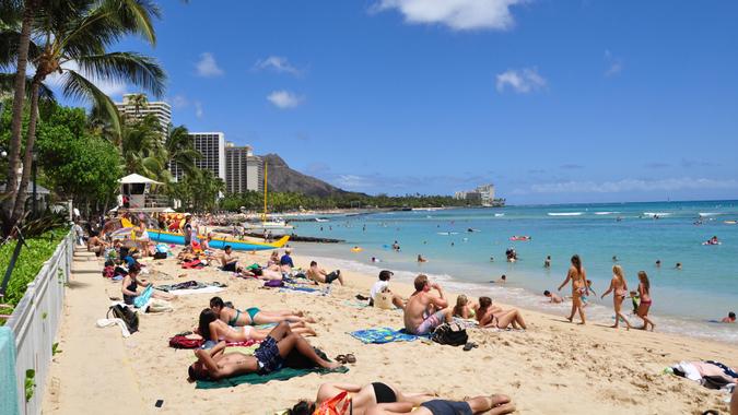 WAIKIKI, HI - MAY 29 - Tourists sunbathing and surfing on Waikiki beach May 29, 2010 in Oahu.