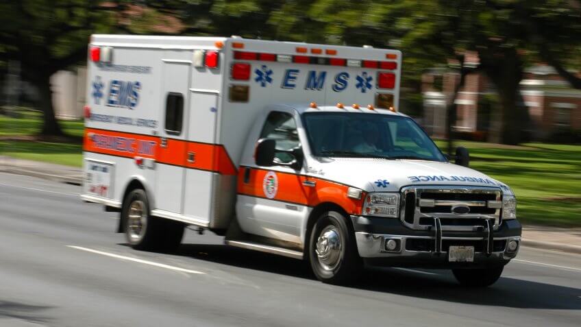 A speeding emergency medical services ambulance, with motion blur.