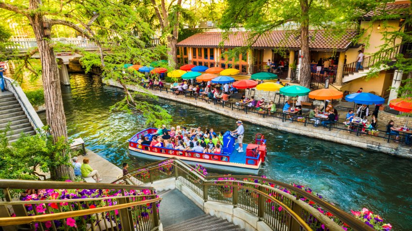 San Antonio, Texas, USA - April 14, 2013: Tourists riding in tour boat and eating at restaurants along The Riverwalk in San Antonio Texas.
