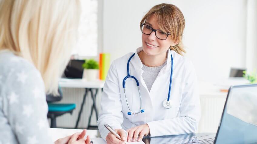 Shot of a middle aged female doctor sitting in front of laptop and consulting with her patient.