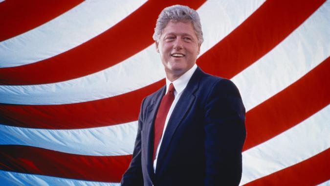 President William Jefferson Clinton in front of American flag stripes.