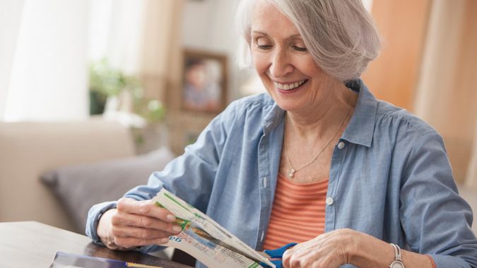  Ältere kaukasische Frau Clipping Coupons.