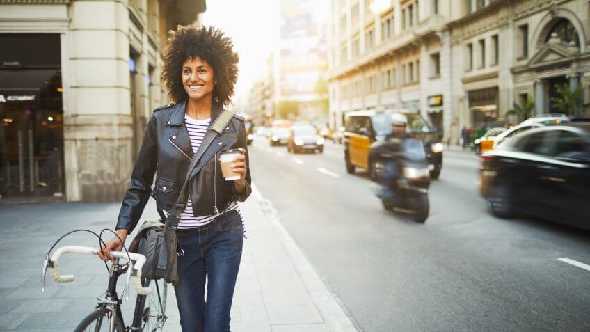 Young hipster woman in the streets of Barcelona commuting.