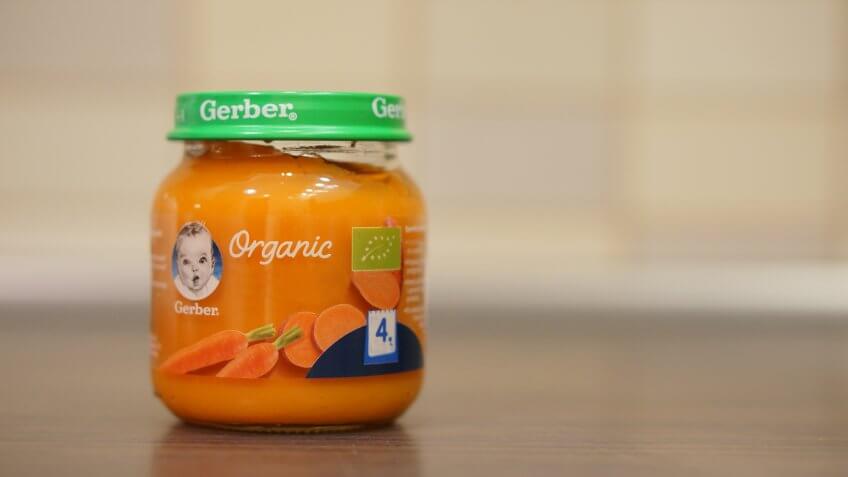 Gerber Organic baby food with carrots and sweet potato for 4 months old in a small glass jar on circa December 2017 in Poznan, Poland.