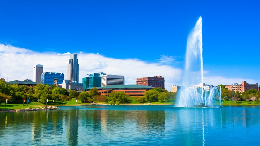 Downtown Omaha skyline with a Lake and a large ornate fountain in the Heartland of America Park.