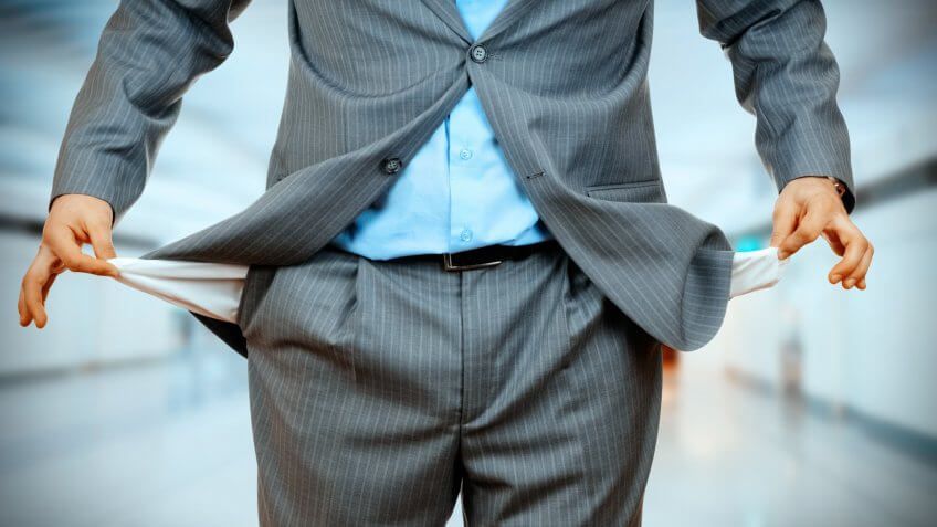 Man Pulling out Empty Pocket on office background.