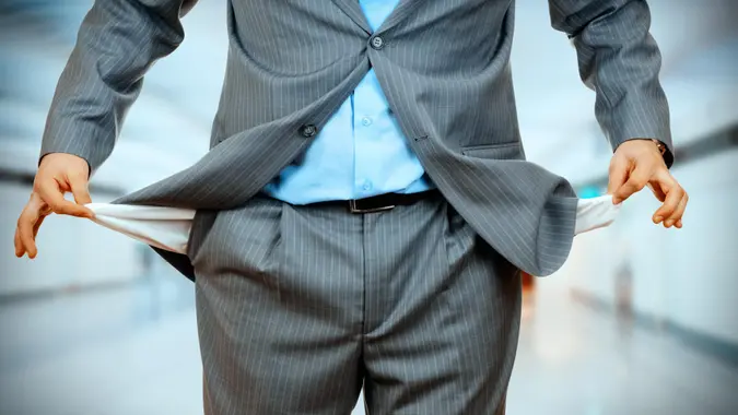 Man Pulling out Empty Pocket on office background.