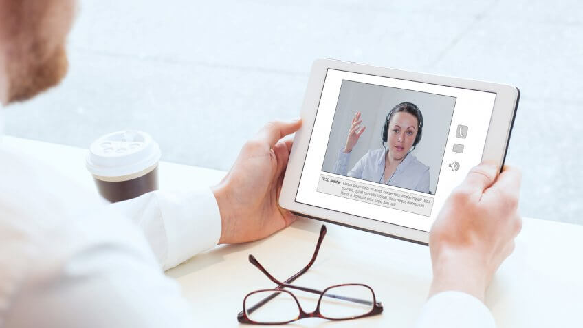 e-learning, video conference, coaching online, man looking at the screen of tablet.