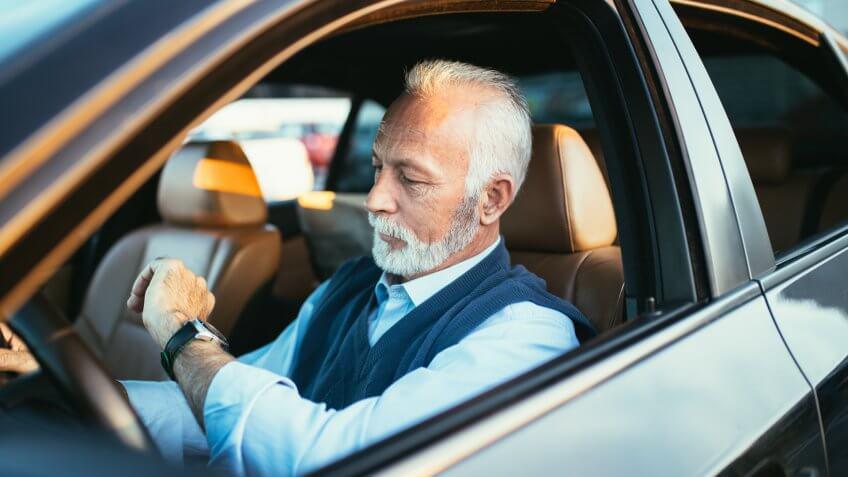 Senior business man sitting in his limousine.