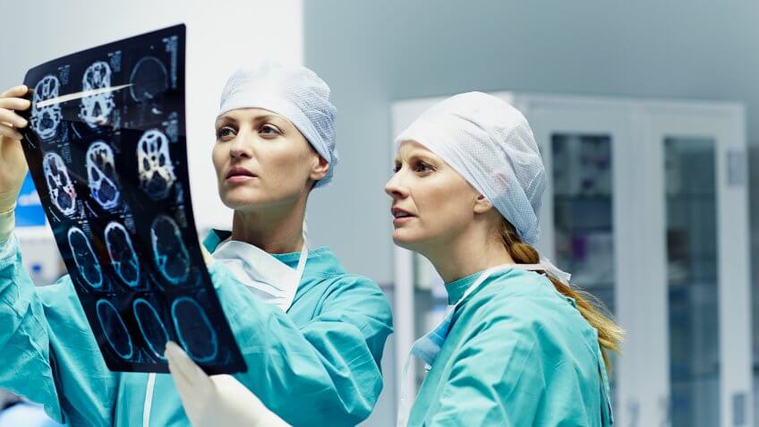 Female surgeons examining x-ray together in hospital.