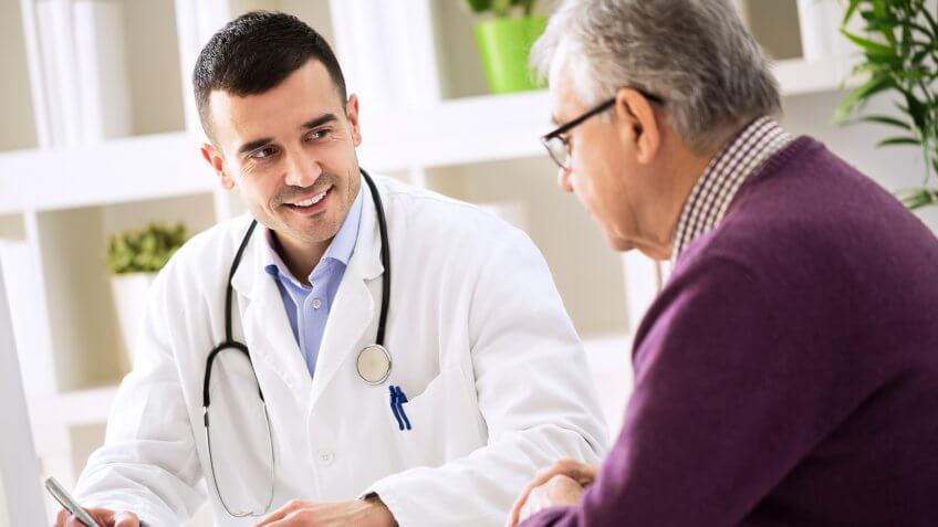 Doctor explaining prescription to senior patient, healthcare concept.
