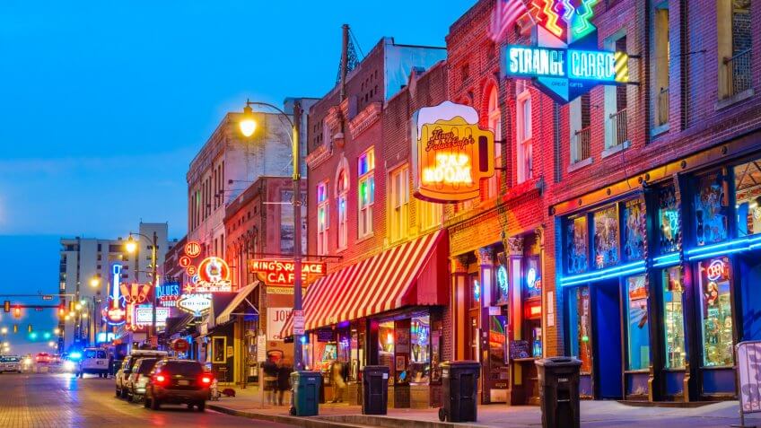 Photo of colorful cafe bars at the iconic Beale Street music and entertainment district of downtown Memphis, Tennessee, USA, illuminated at night.