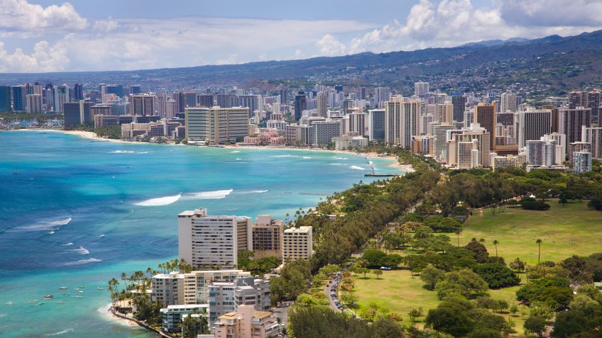 Aerial view of the Honolulu skyline and Waikiki Beach with crystal clear turquoise waters.