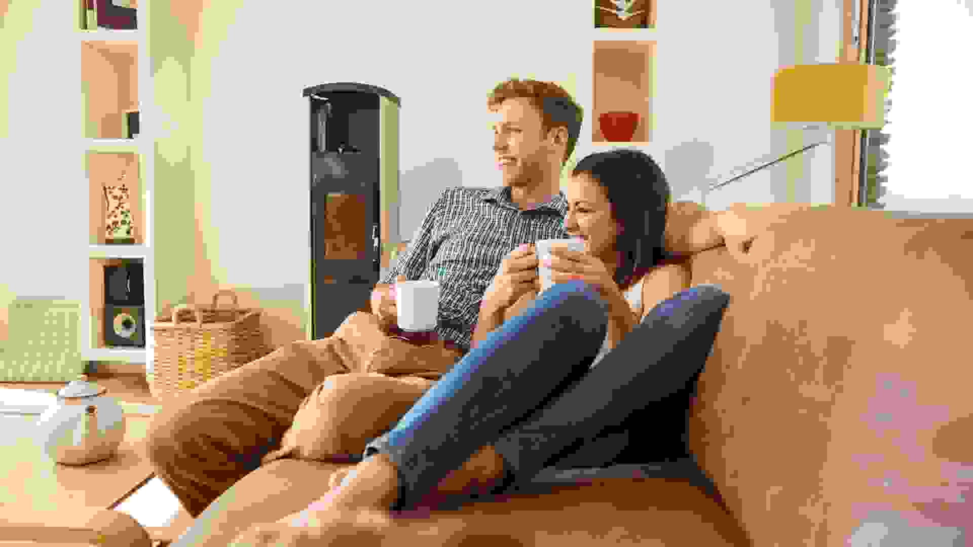Happy young couple relaxing on the couch at home in the living room.