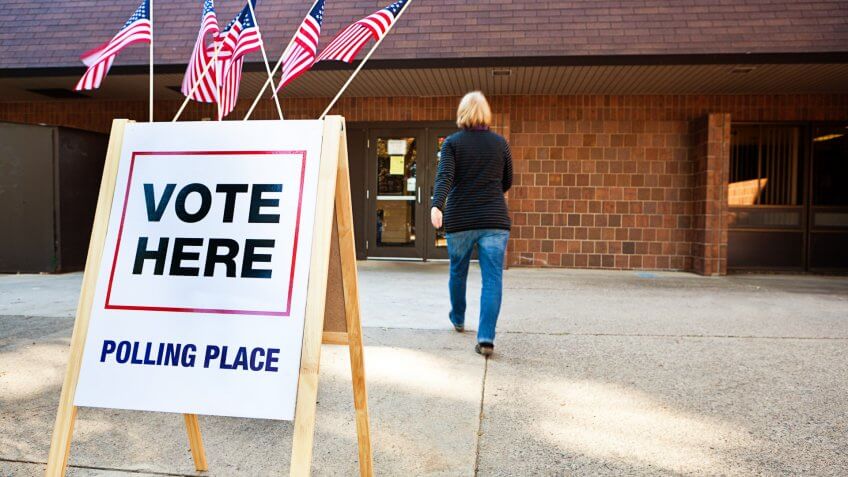 Unidentifiable woman voter entering a voting polling place for USA government election.