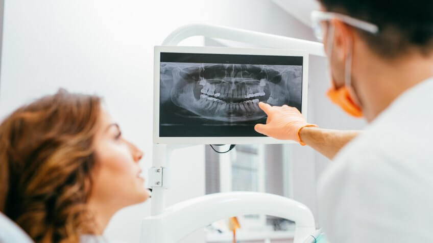 Dentist and patient looking at a digital dental x-ray.