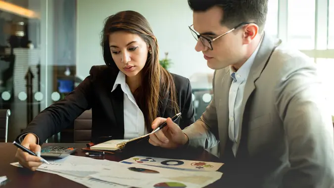 Businessman and businesswoman discuss together about there business performance.