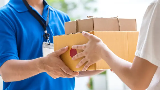 Woman hand accepting a delivery of boxes from deliveryman.