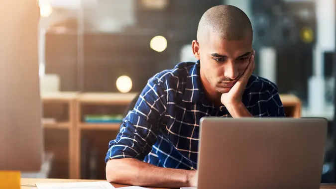 Cropped shot of a young designer looking bored while working at his office desk.