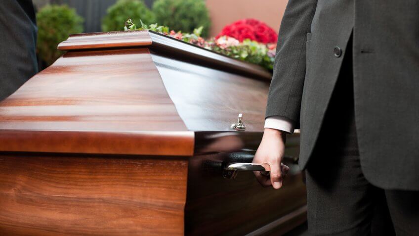 Dolor - Funeral with coffin on a cemetery, the casket carried by coffin bearer.