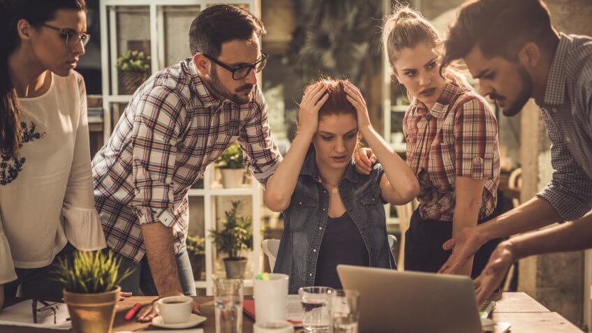 Group of worried freelance workers having problems during a meeting at casual office.