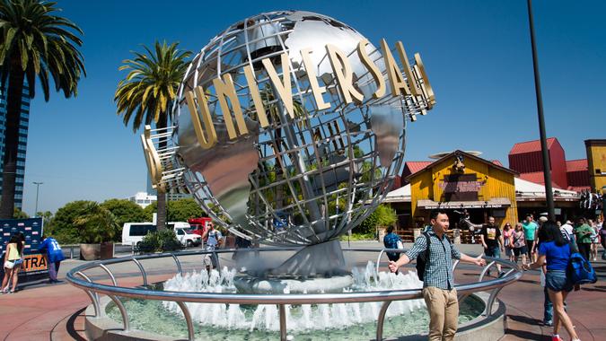 Los Angeles, California, USA - May 27, 2014: Universal Studios Hollywood globe outside the theme park entrance with visitors enjoying during a sunny day.