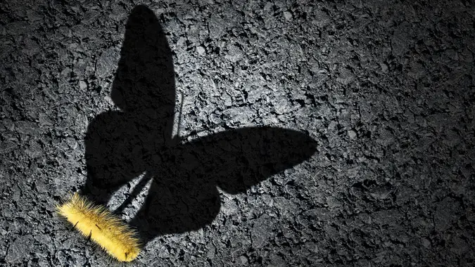 Aspiration concept and ambition idea as a caterpillar casting a shadow odf a butterfly as an achievement and hope for futur success symbol with 3D illustration elements.