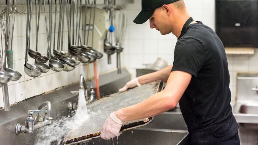 young dishwasher working at a restaurant kitchen.