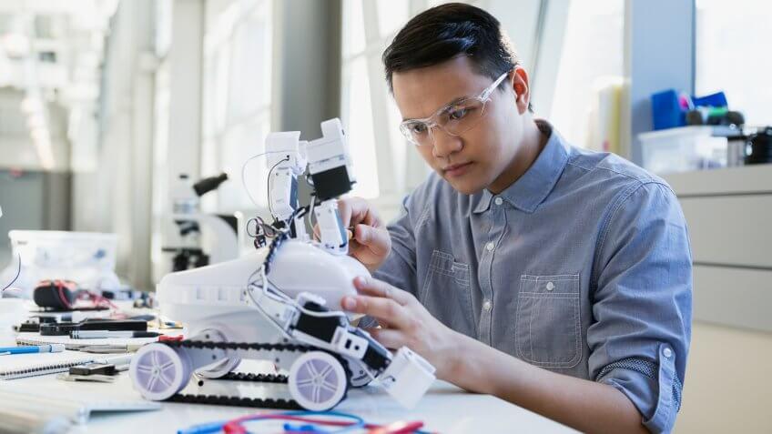 Focused engineer assembling robotic car.