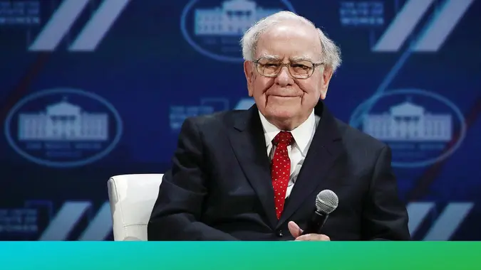 Warren Buffett holds a microphone
