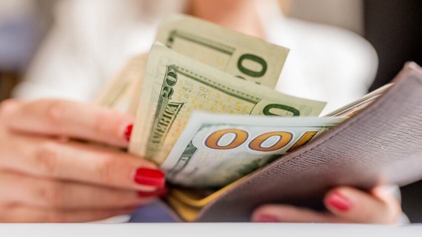 people, business, finances and money concept - close up of businesswoman hands holding open wallet with dollar cash.