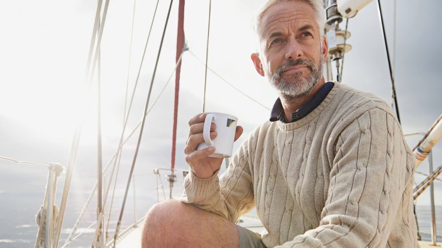 Shot of a mature man on his sailboat drinking a cup of coffee.