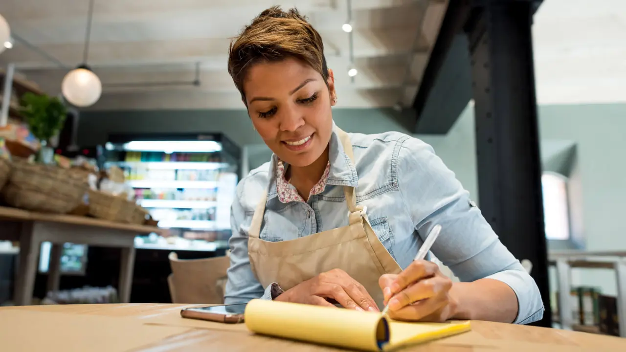 Business woman working at a restaurant and looking very happy - woman entrepreneur concepts.