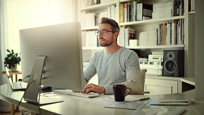 Cropped shot of a man sitting behind his computer in his home office.