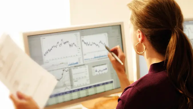 A businesswoman making changes to a graph on the computer using a stylus.