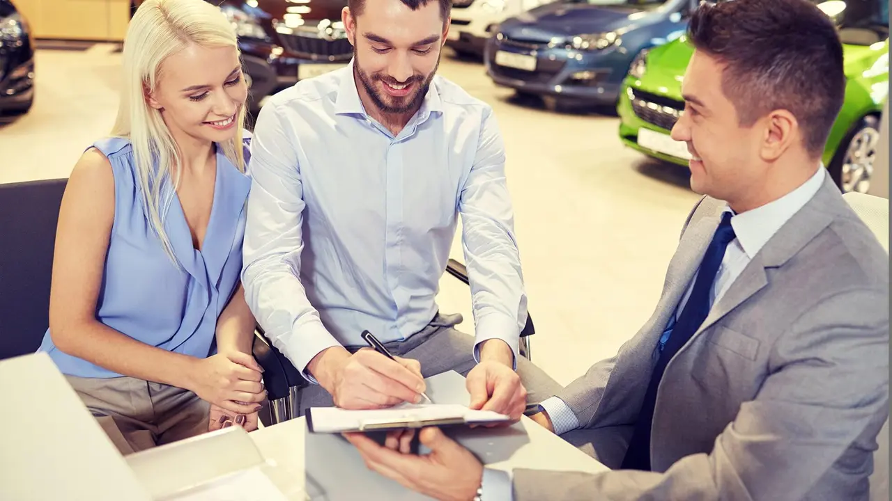 Couple at the dealership filling out paperwork
