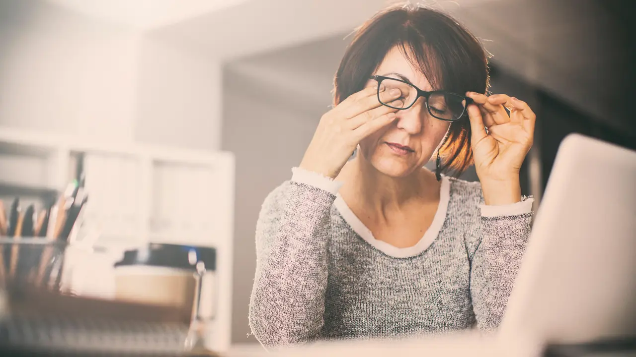 Tired woman rubbing eyes
