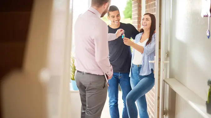 a young couple view a property guided by an estate agent