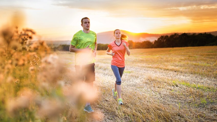 Cross-country trail running people at sunset.