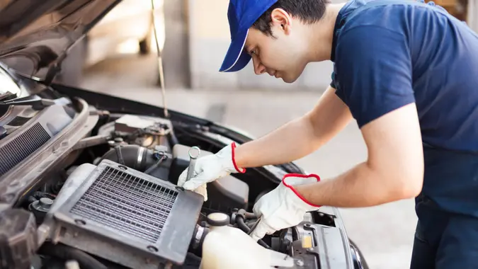 Mechanic using a wrench to repair a car engine.