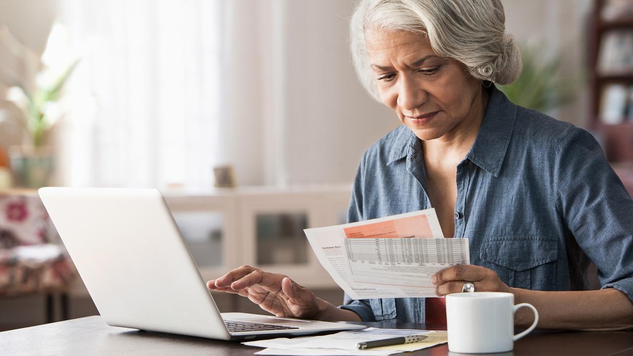 Older woman paying bills on laptop.
