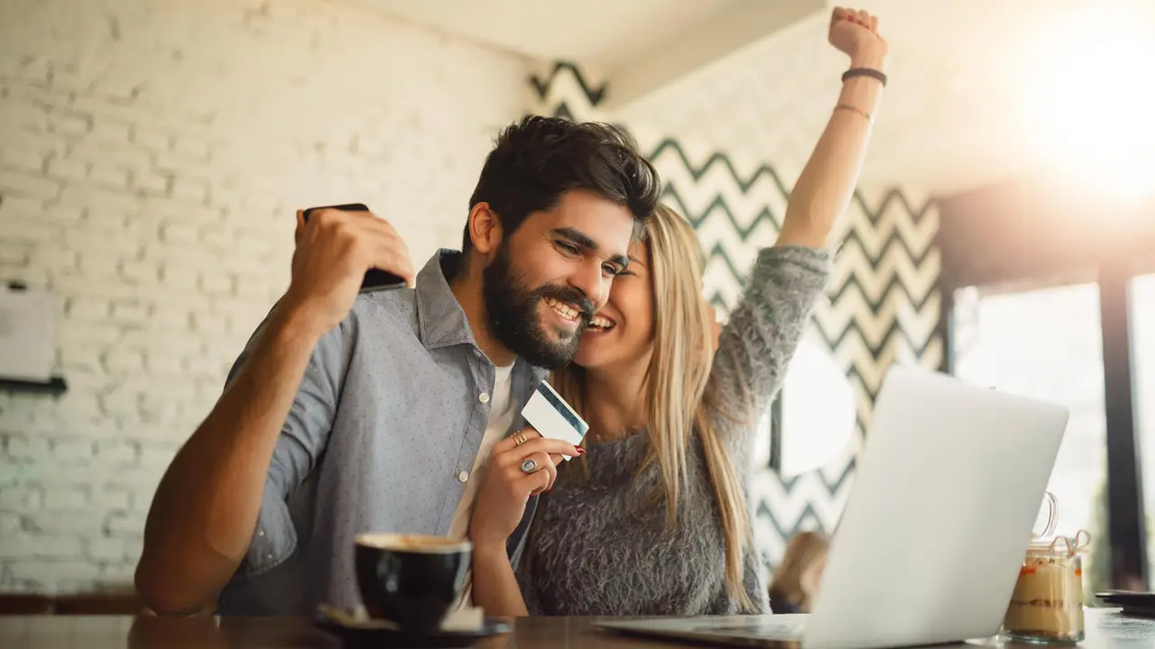couple reading good news on laptop