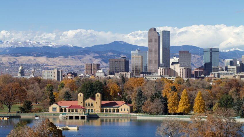 Scenic of Denver Colorado skyline, with Rocky Mountains in the background and City Park Lake in the