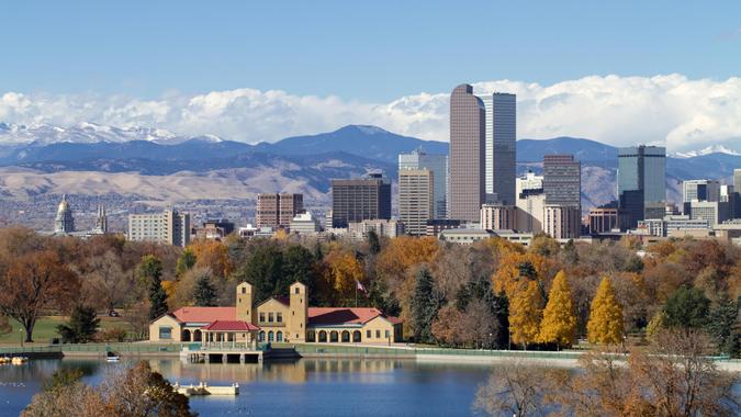Scenic of Denver Colorado skyline, with Rocky Mountains in the background and City Park Lake in the