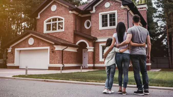 family standing near their modern house