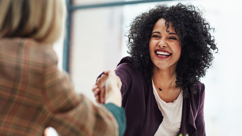 colleagues shaking hands during a meeting at work.