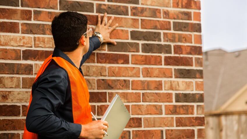 inspector examines residential home exterior