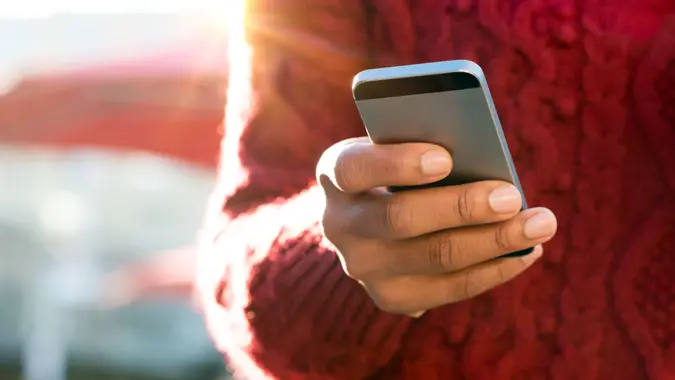 Close-up of a young woman's hand typing a text message on her smartphone
